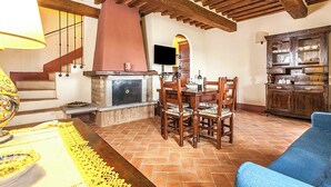 Un comedor con mesa y sillas de madera, una chimenea y un televisor.