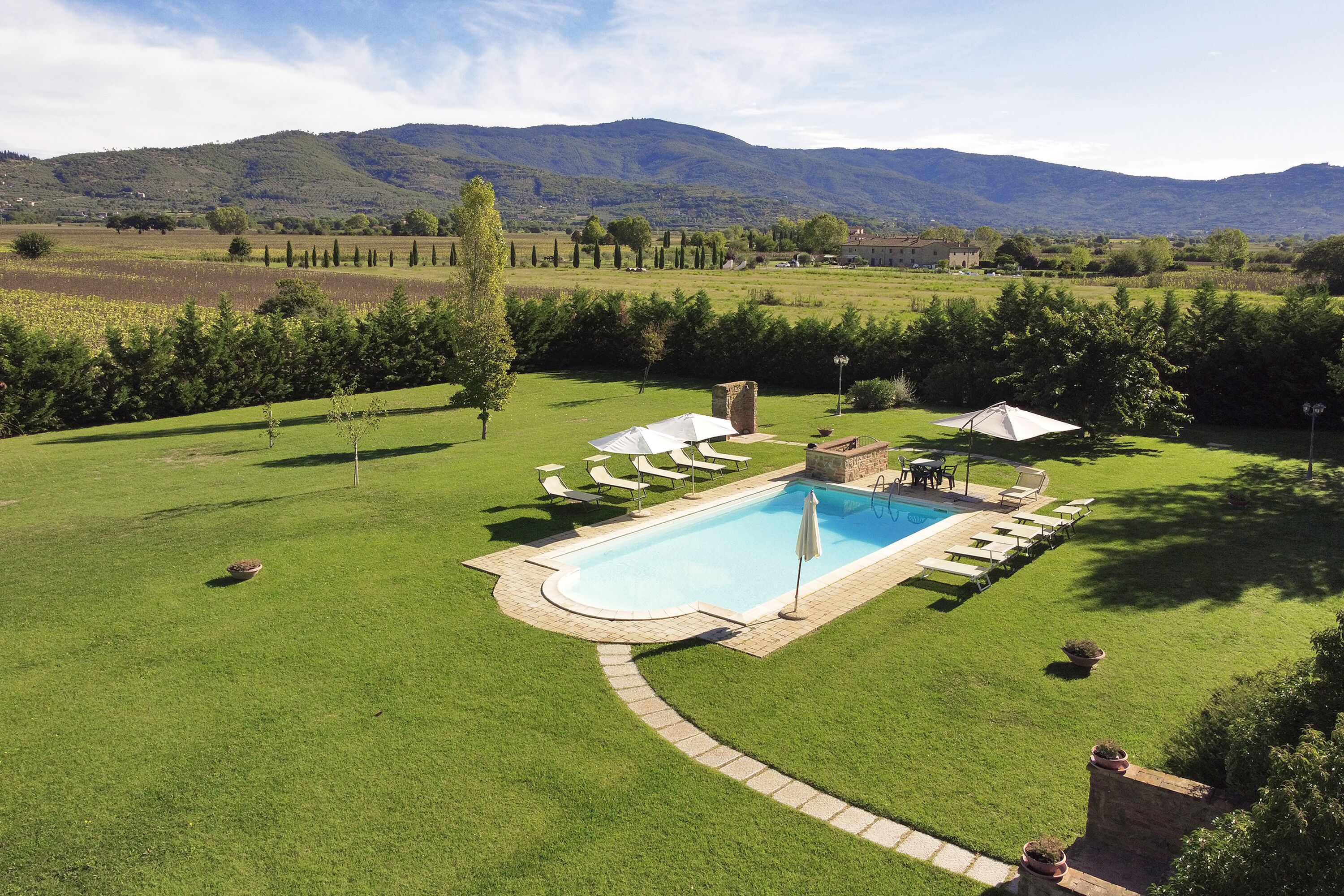 Un espace piscine offrant une vue dégagée sur le paysage environnant, notamment sur une chaîne de montagnes en arrière-plan.