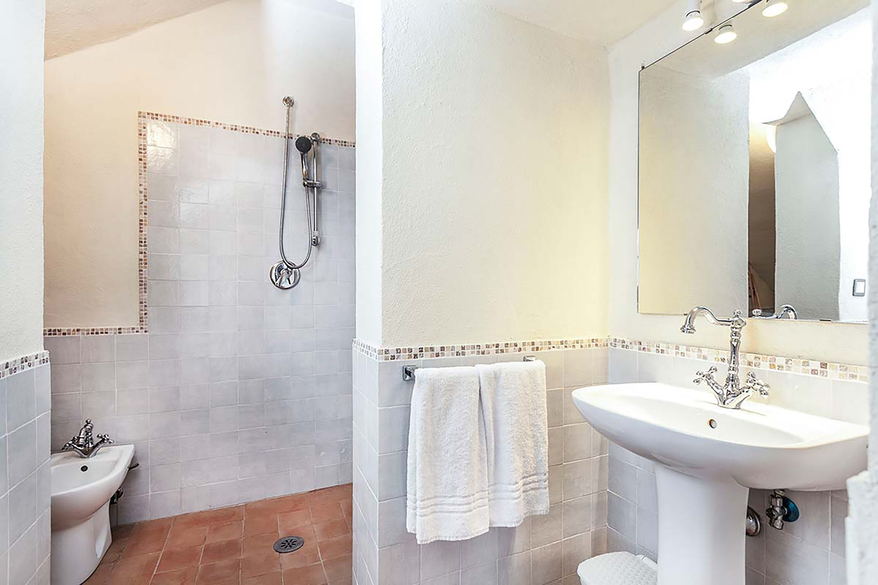 A bathroom with a shower, a sink, and a mirror.