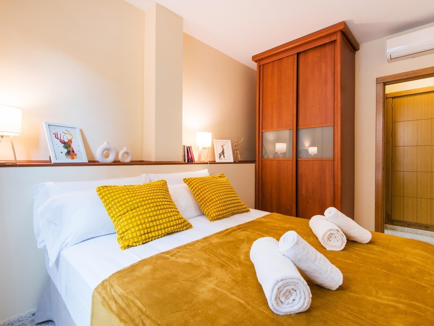 Une chambre d’hôtel avec un lit, une armoire en bois et une porte.