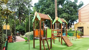A playground with climbing structures, slides, and a small bridge.