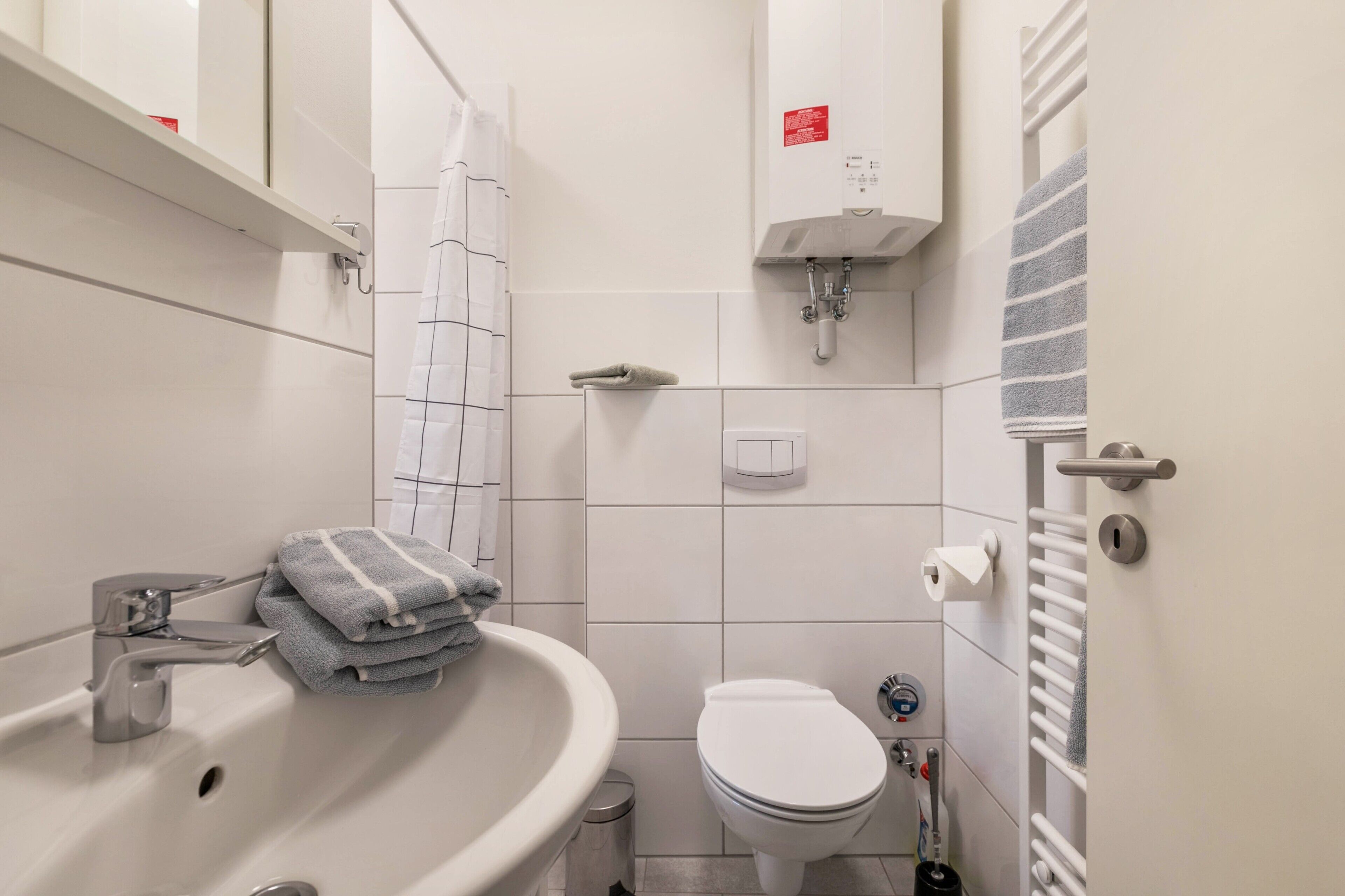 Ein Badezimmer mit Waschbecken, Toilette, Handtuchhalter und einem Handtuch.