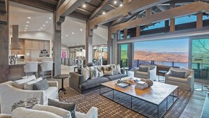 A spacious living area with a large sofa, coffee table, and seating arrangement. - Dreamscape 365 | Ski-In/Ski-Out, Arcade & Hot Tub (Park City)