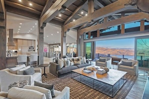 A spacious living area with a large sofa, coffee table, and seating arrangement. - Dreamscape 365 | Ski-In/Ski-Out, Arcade & Hot Tub (Park City)