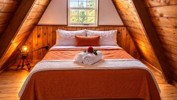 Une chambre mansardée chaleureuse, avec un plafond en pente, un lit recouvert d’une couverture orange, un tapis blanc et moelleux, et une fenêtre donnant sur un paysage verdoyant.