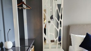 Un dormitorio moderno con cama, mesita de noche y un armario blanco de diseño único.