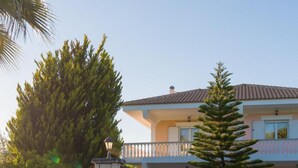 Une maison à deux étages avec un mur en pierre et une cour dallée de pierres.