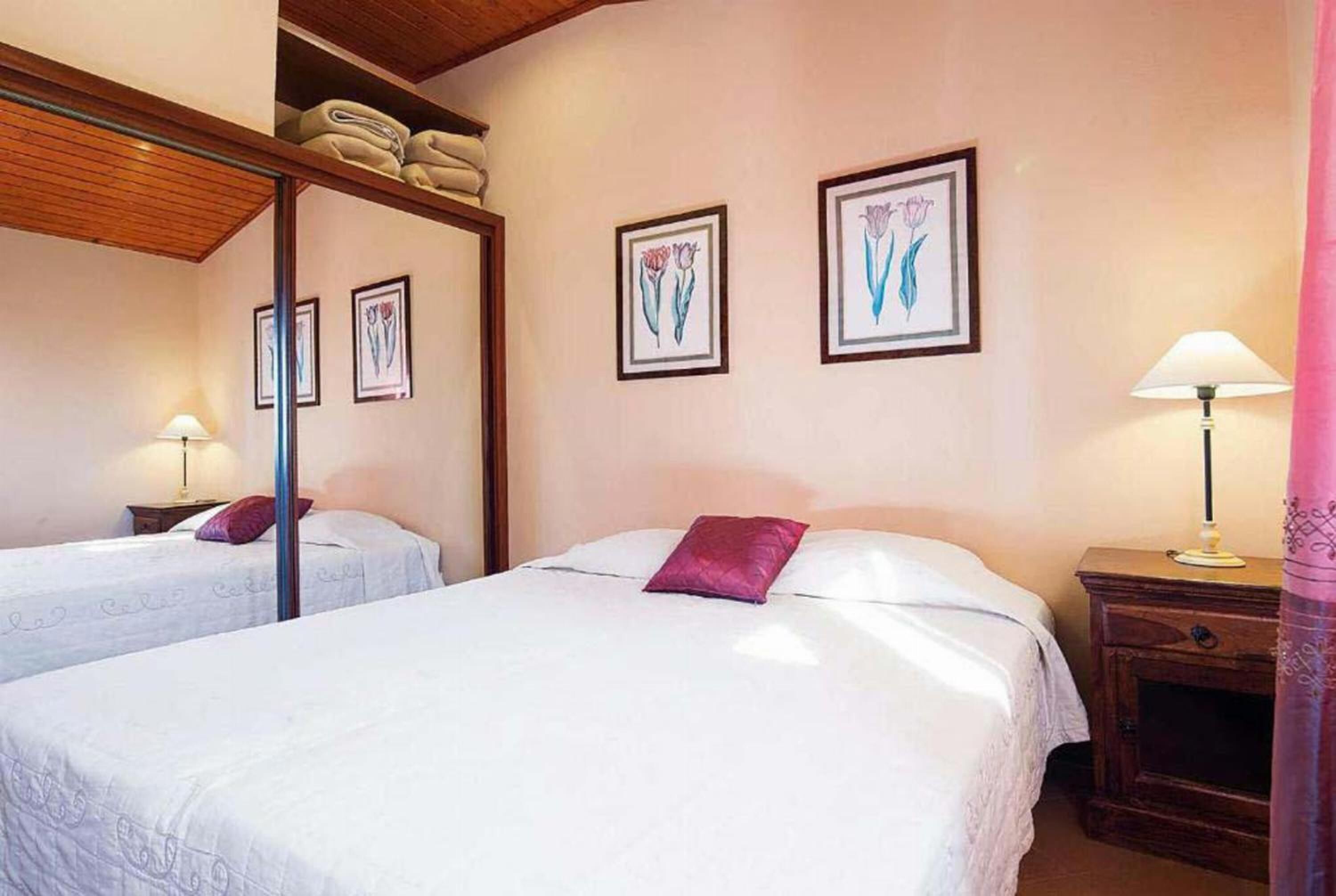 Une chambre d’hôtel avec deux lits, un plafond en bois et des œuvres d’art encadrées accrochées aux murs.