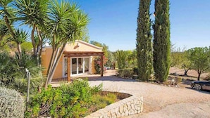 A house with a patio, surrounded by cypress trees and a gravel driveway. - Villa Irene in Mexilhoeira Grande (Portimão)