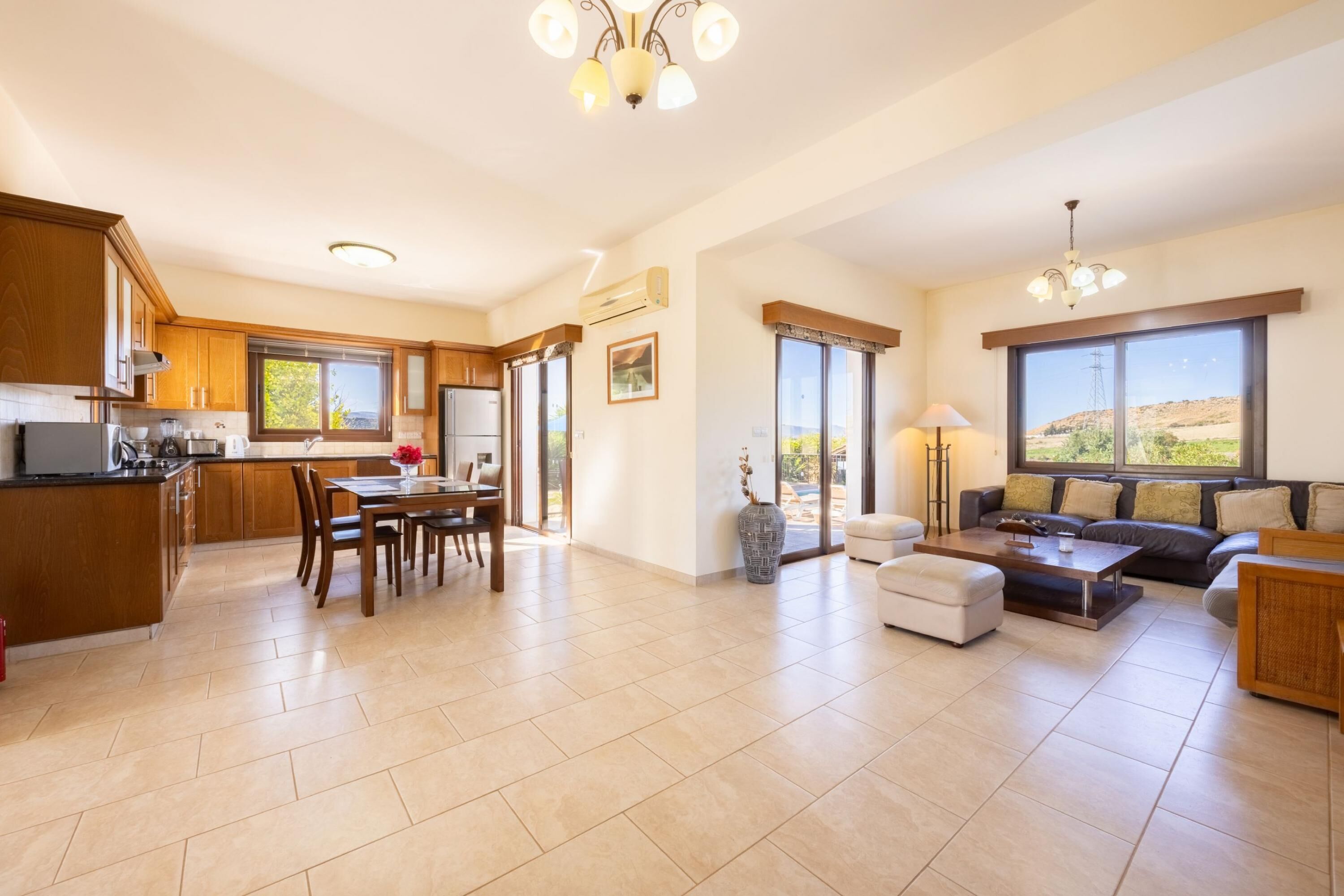 A spacious living area with a dining table, sofa, and a view of the outdoors.
