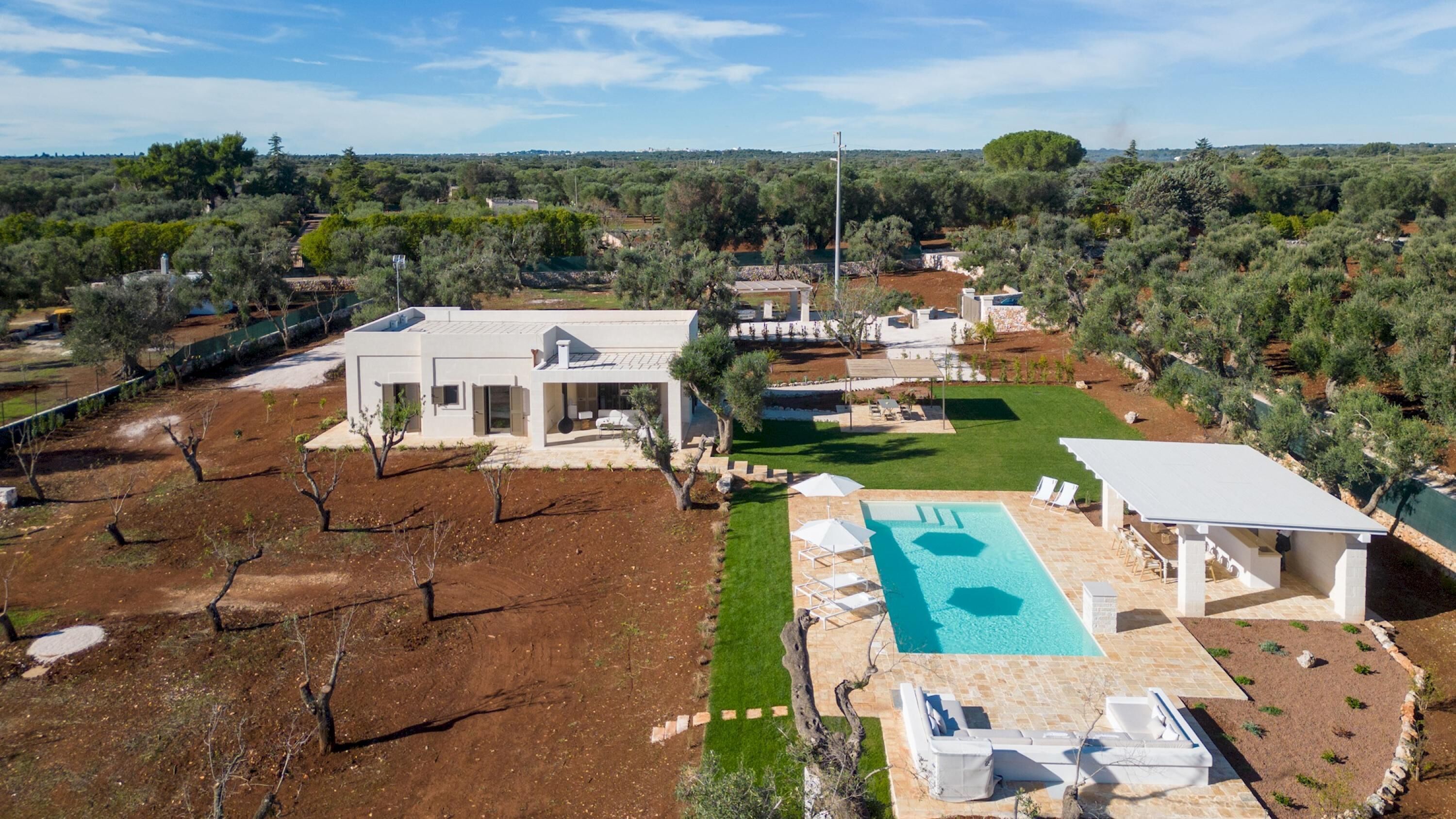 A modern villa with a swimming pool, a patio area, and a well-maintained garden.