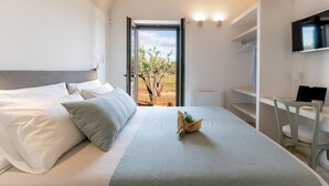 A modern bedroom with a bed, a desk, and a TV. - Villa Belkis 6 Emma Villas (Ostuni)