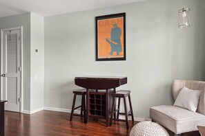 A room with a piano, a sofa, and a framed artwork on the wall.