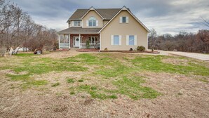 A two-story house with a front porch, a garage, and a well-maintained lawn.