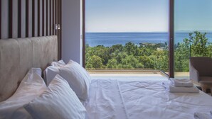 Un dormitorio con una cama grande, vistas al mar y un balcón.