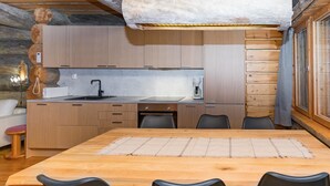 Une cuisine moderne avec des meubles en bois, un îlot central et un coin repas comprenant une table et des chaises.