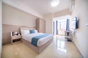A modern hotel room with a large bed, bedside table, and a TV. - Moon Hotel Apartment Guangzhou Baijiang (Guangzhou)
