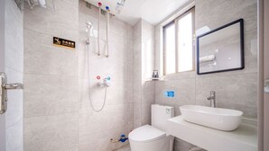 A modern bathroom with a toilet, bidet, and sink. There is a sign on the wall and a window above the sink. - Moon Hotel Apartment Guangzhou Baijiang (Guangzhou)