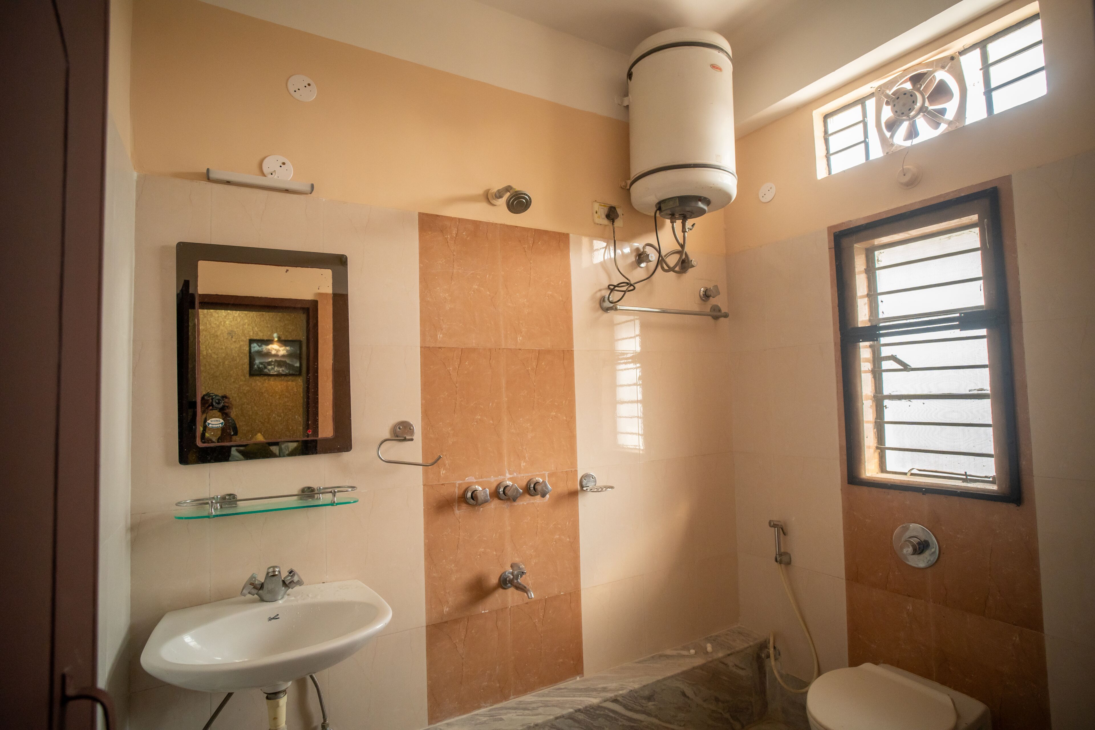 A bathroom with a sink, mirror, shower, and toilet.