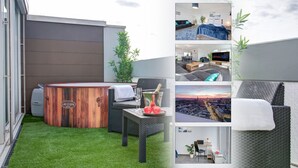 A modern outdoor lounge area with a hot tub, seating, and a view of the cityscape.