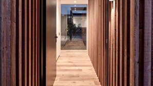 A modern hallway with wooden paneling on both sides and a wooden floor. - Te Whare Waipara

 (Broomfield)