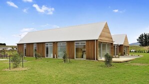 A modern building with a flat roof, large glass windows, and wooden paneling. - Te Whare Waipara

 (Broomfield)