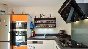 A modern kitchen with a built-in oven, a dishwasher, a coffee maker, and a sink. - Peaceful Forest Stay in Pédernec (Pedernec)