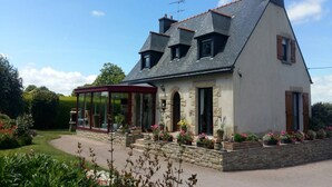 A two-story house with a sloped roof, a covered porch, and a stone foundation. - Peaceful Forest Stay in Pédernec (Pedernec)