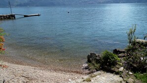 Un lac avec une jetée qui s’avance sur l’eau, entouré de montagnes et sous un ciel dégagé.