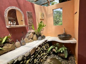 A bathroom with a stone sink, a mirror, and a small window. - duegoal farmhouse (Penebel)