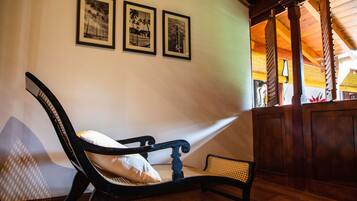 Une pièce comprenant un lit, une chaise et deux tableaux encadrés accrochés au mur.