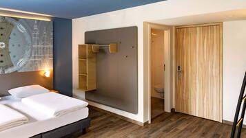 Un dormitorio moderno con cama, armario de madera, baño y estante fijado a la pared.