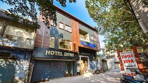 A building with a sign reading "HOTEL DIVA" and another sign advertising "Hotel Diva Luxury Rooms." - FabExpress Divya Villa (New Delhi)