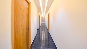 Un pasillo con puertas de madera, numeradas 213, y suelo de mármol negro.