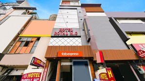 Un hotel llamado "HOTEL ROYAL M.G" con un letrero llamativo, una fachada con diversos elementos arquitectónicos y una entrada visible.