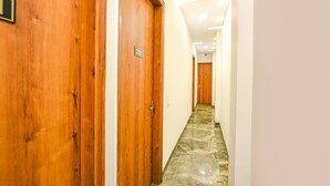 Un pasillo con puertas de madera, con los números 202 y 203, que dan a habitaciones.