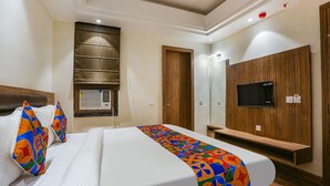 A hotel room with a bed, a TV mounted on the wall, a wooden wardrobe, and a window with blinds. - Fabhotel Stargaze (Kanpur)