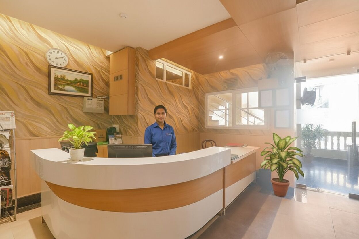 A reception desk with a marble wall, a clock, and a framed picture.