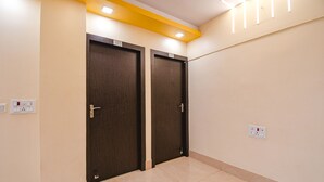 A hallway with two doors marked 403, a light switch, and a power outlet on the wall. - Fabhotel New Annapurna Plaza (Barasat)