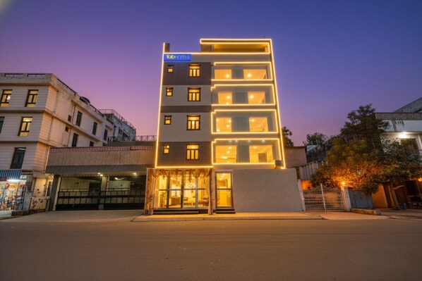 Un hôtel moderne, doté d’une enseigne bien visible, de plusieurs étages et d’une entrée bien éclairée.