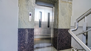 An elevator with a metallic finish, a control panel, and a marble-tiled floor. - Fabhotel Hamsa The Right Choice (Hyderabad)