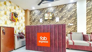 Un espace d'accueil avec une enseigne indiquant « service rapide et impeccable », un comptoir d'accueil en bois, un canapé et un mur décoré de motifs.