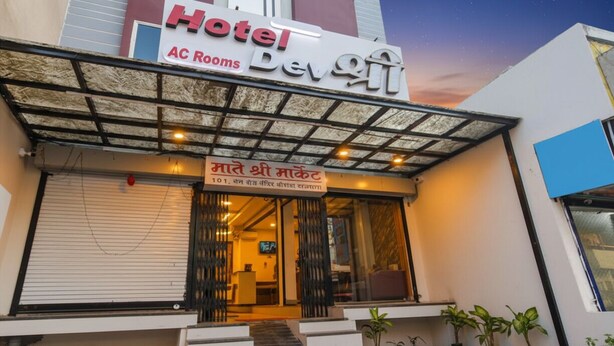 Un hôtel avec une enseigne indiquant qu’il propose des chambres climatisées et dont le nom est écrit dans une langue locale.