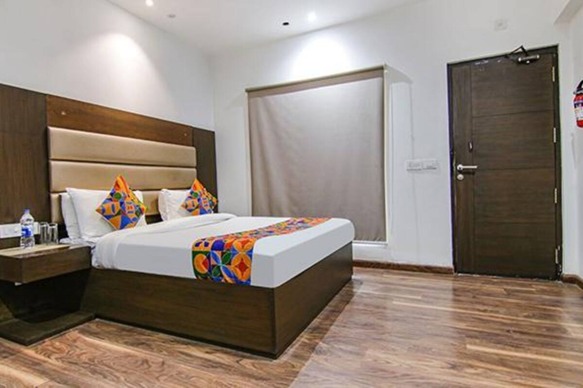 Ein Schlafzimmer mit einem großen Bett, einem Holz-Kopfteil, Nachttischen und einer Tür.