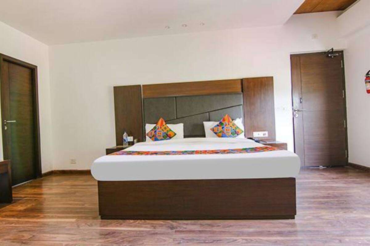 Ein Schlafzimmer mit einem großen Bett, einem hölzernen Kopfteil und Holzboden.