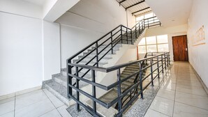 Una escalera con barandas de metal y piso de baldosas, que lleva a un nivel superior.