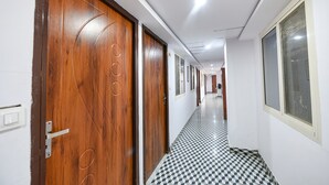 Un pasillo con puertas de madera y suelo a cuadros.