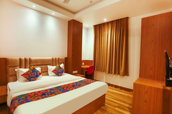 A hotel room with a large bed, a desk, and a chair. - Fabhotel Prime Swarn Bhoomi (Kanpur)