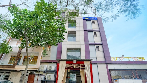 A multi-story building with a 'fab hotels' sign, a red and white entrance, and air conditioning units outside. - Fabhotel Uday Villa (Kanpur)