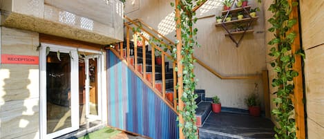 A staircase with wooden railings and potted plants.